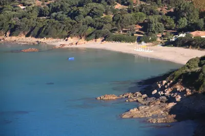 an aerial view of a beach with a boat in the water at Residence Helios in Cargèse