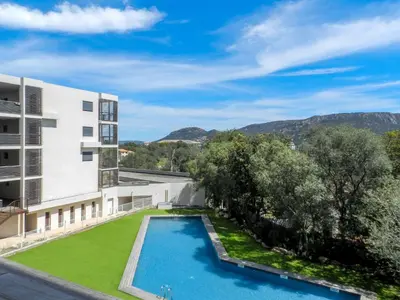 an exterior view of a building with a swimming pool and trees at Apartment Résidence Cita di Sali-9 by Interhome in Porto-Vecchio