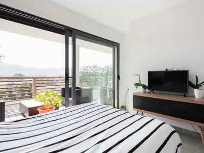 a bedroom with a bed and a large window at Apartment Résidence Cita di Sali-9 by Interhome in Porto-Vecchio