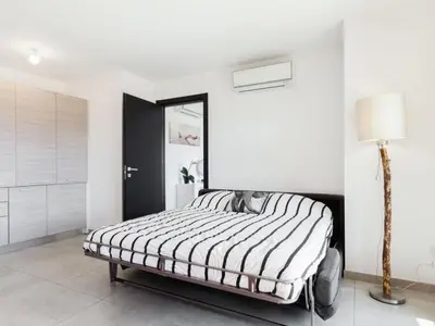 a bedroom with a bed with a black and white comforter at Apartment Résidence Cita di Sali-9 by Interhome in Porto-Vecchio