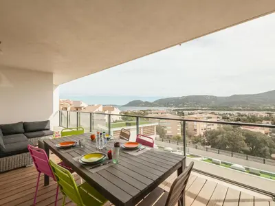 a dining room with a table and chairs on a balcony at Apartment Château-10 by Interhome in Porto-Vecchio