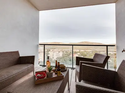 a living room with two chairs and a table with a drink at Studio Château-11 by Interhome in Porto-Vecchio