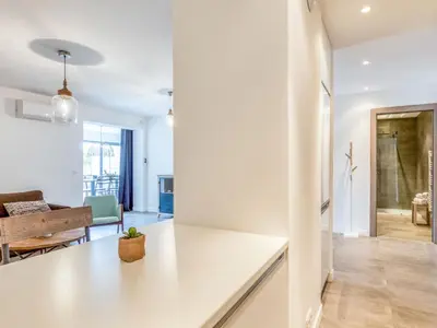 a kitchen with white cabinets and black appliances at Apartment Bastion-3 by Interhome in Porto-Vecchio