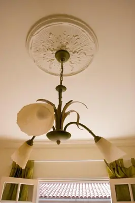 a chandelier hanging from a ceiling with a window at A l'ombre du clocher in Calenzana