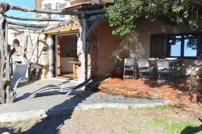 a patio with chairs and a table in front of a house at CAROLE F4 in Zonza