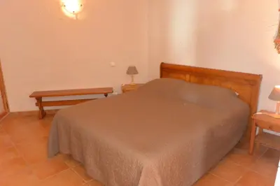 a bedroom with a bed and two tables and a bench at CAROLE F4 in Zonza