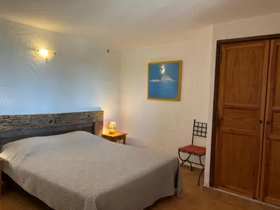 a bedroom with a bed and a wooden cabinet at CAROLE F4 in Zonza