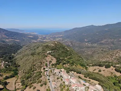 an aerial view of a mountain with houses and trees at Charmante maison de village *** in Santa-Maria-Figaniella