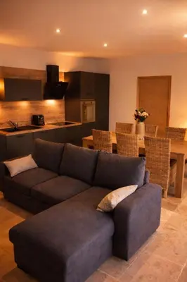 a living room with a couch and a kitchen at Charmante maison de village *** in Santa-Maria-Figaniella