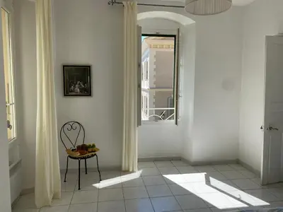 a white hallway with a chair and a window at Casa Eugénie l'appartement de tante Madeleine vue sur les montagnes in Venaco