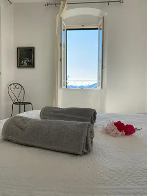 a bedroom with a large bed with a window at Casa Eugénie l'appartement de tante Madeleine vue sur les montagnes in Venaco