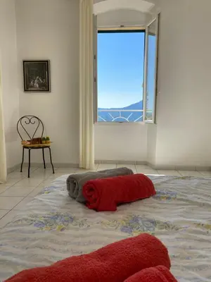 a large bed in a room with a window at Casa Eugénie l'appartement de tante Madeleine vue sur les montagnes in Venaco
