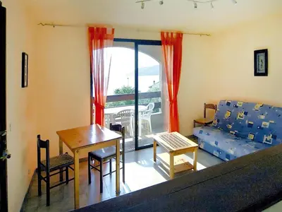 a living room with a couch and a table at Residence Les Dauphins in Tiuccia with balcony in Casaglione