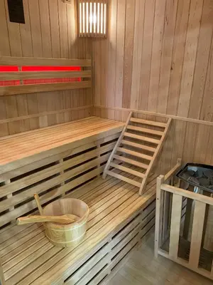 a sauna with wooden shelves and a bucket in it at Appartement avec jacuzzi in Porto-Vecchio