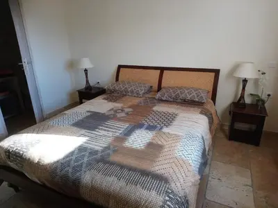 a bedroom with a large bed with two lamps at Les Hauts de Cavanello in Zonza