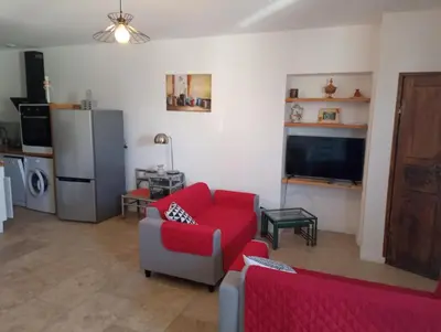 a living room with a red couch and a tv at Casa Padulella in Moriani Plage