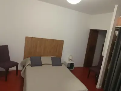 a bedroom with a white bed and two chairs at Casa Padulella in Moriani Plage