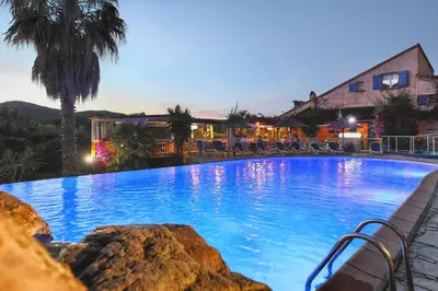 a large blue swimming pool in front of a building at Residence Fium Del Cavo in Sainte-Lucie de Porto-Vecchio