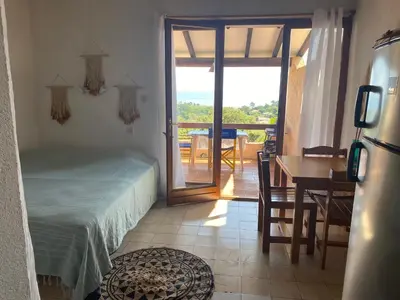 a bedroom with a bed and a table with a view at Residence Fium Del Cavo in Sainte-Lucie de Porto-Vecchio