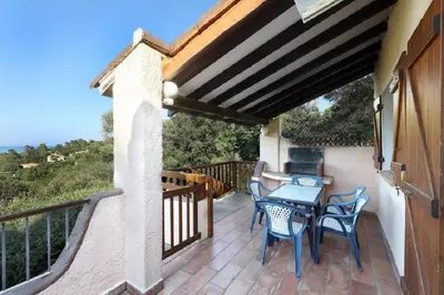 a patio with a table and chairs on a balcony at Residence Fium Del Cavo in Sainte-Lucie de Porto-Vecchio