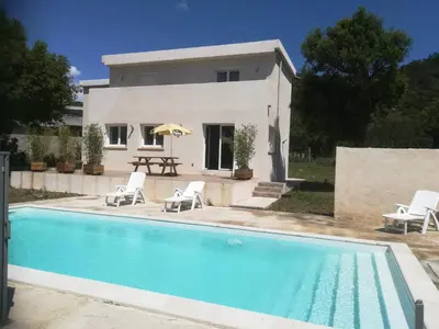 a villa with a swimming pool in front of a house at Chambre d'hôte l'Escale in Sainte-Lucie de Porto-Vecchio