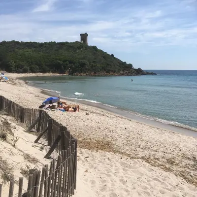 a group of people laying on a beach next to the ocean at Chambre d'hôte l'Escale in Sainte-Lucie de Porto-Vecchio