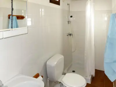 a white bathroom with a toilet and a shower at Résidence Mari di Soli in Porto-Vecchio