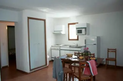 a kitchen with a table and a dining room at Résidence Mari di Soli in Porto-Vecchio