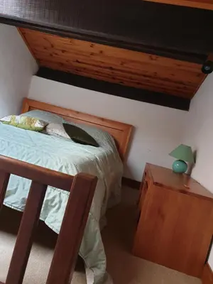 a bedroom with a bed and a table with a lamp at STUDIO avec Mezzanine in Corte