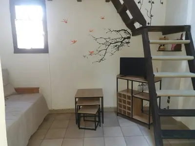 a bedroom with a bunk bed and a staircase in a room at STUDIO avec Mezzanine in Corte