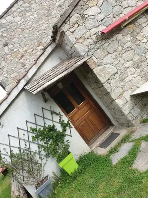 a house with a wooden door on the side of it at STUDIO avec Mezzanine in Corte
