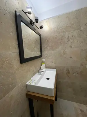 a bathroom with a white sink and a mirror at Hotel Clair de Lune in Zonza