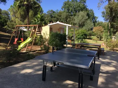 a ping pong table in front of a playground at Résidence EMILIA in Santa-Maria-Poggio