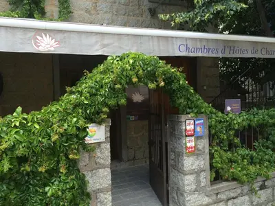 an entrance to a building with a green hedge at Aux Bords du Temps in Zonza
