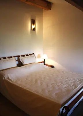 a bedroom with a large white bed with two pillows at Aux Bords du Temps in Zonza