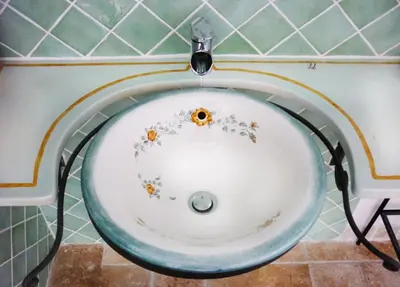 a sink in a bathroom with flowers on it at Aux Bords du Temps in Zonza