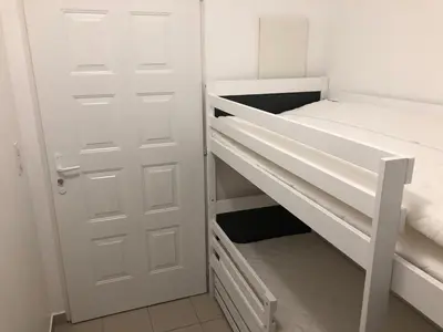 a room with two bunk beds and a door at Porticcio centre plage à pieds, studio-cabine 4 Pers max, promo 7 nuits in Porticcio
