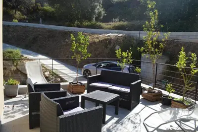 a patio with chairs and a couch and a table at La Villa Volpaso in Belgodère