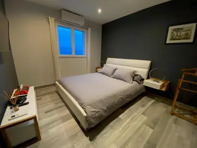 a bedroom with a bed and a table and a window at La Villa Volpaso in Belgodère
