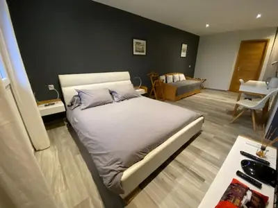 a bedroom with a bed and a living room at La Villa Volpaso in Belgodère