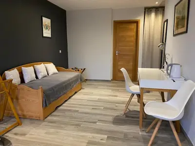 a bedroom with a bed and a table and chairs at La Villa Volpaso in Belgodère