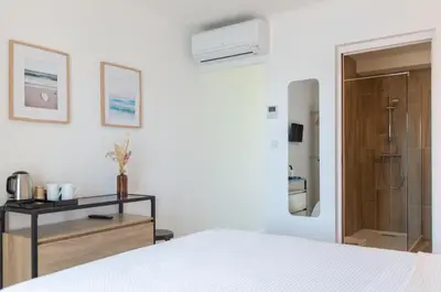 a white bedroom with a bed and a bathroom at HOTEL CAMPOMORO in Campomoro