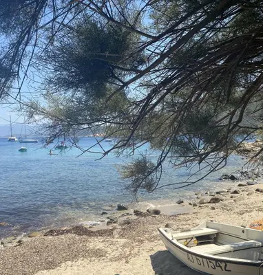 a boat sitting on a beach next to the water at HOTEL CAMPOMORO in Campomoro