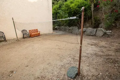 a net in front of a building with a bench at costa di sognu in Costa