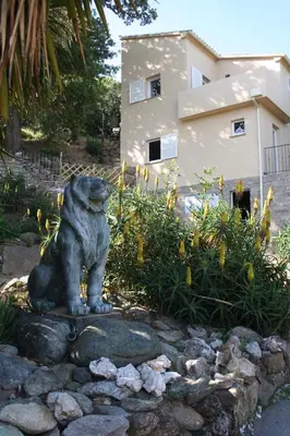 a statue of a dog sitting on a rock at costa di sognu in Costa