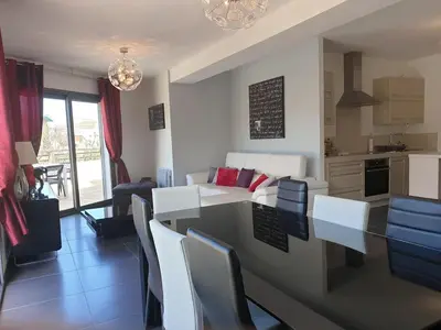 a kitchen and living room with a table and chairs at APPARTEMENT TERRASSE CITA DI SALI PORTO VECCHIO in Porto-Vecchio