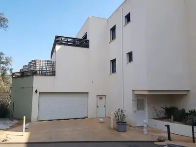 a large white house with a garage at APPARTEMENT TERRASSE CITA DI SALI PORTO VECCHIO in Porto-Vecchio