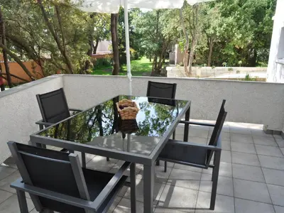 a glass table with four chairs and an umbrella at Holiday Home in Moriani-Plage near Beach in San-Nicolao