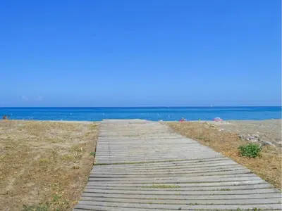 a wooden path leading to the beach at Holiday Home in Moriani-Plage near Beach in San-Nicolao