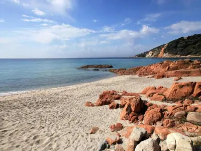 a sandy beach with red rocks and the ocean at Romantic Retreat in Cargèse in Cargèse